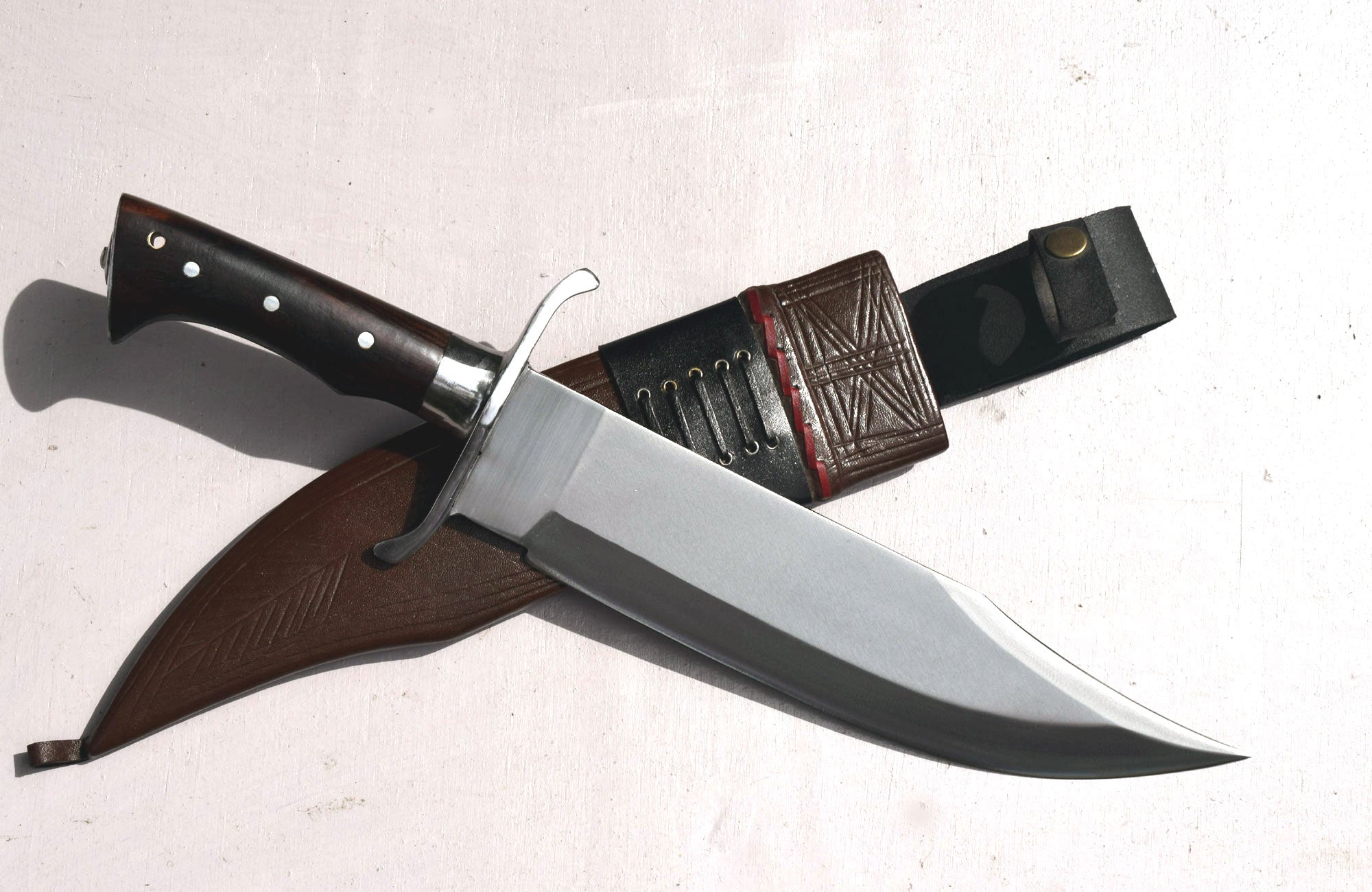 Bowie knife handle detail showing rosewood with cross-hatch grip pattern and metal guard